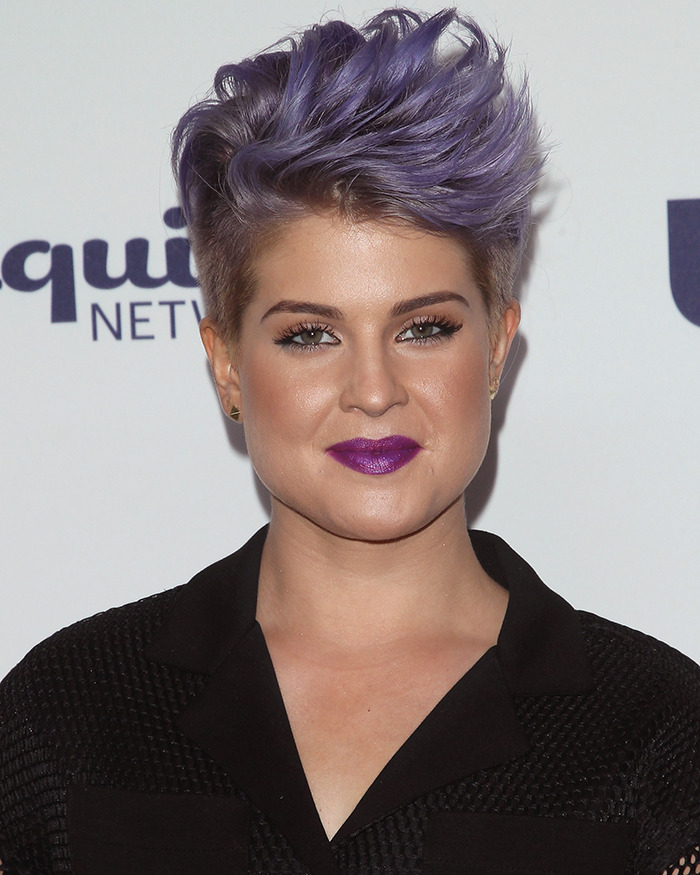 Kelly Osbourne with short purple hair and bold lipstick, showcasing her stunning transformation amid Ozempic and plastic surgery rumors.