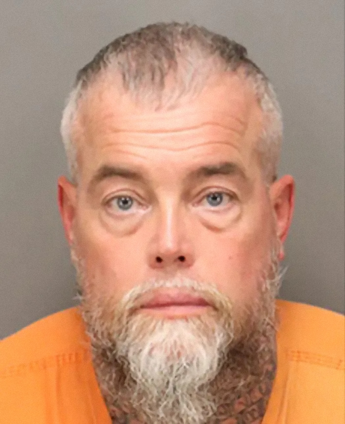 Man with gray beard and orange shirt in mugshot photo after winning lottery and getting arrested Man with gray beard and orange shirt in mugshot photo after winning lottery and getting arrested