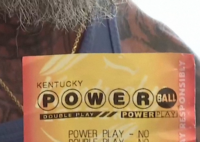Lottery ticket held by a man with a beard and tattoos, related to winning $167 million in lottery news. Lottery ticket held by a man with a beard and tattoos, related to winning $167 million in lottery news.