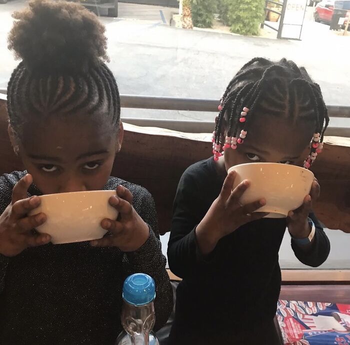 Two children drinking from bowls indoors, illustrating Charlize Theron's children showing zero respect in a candid moment.