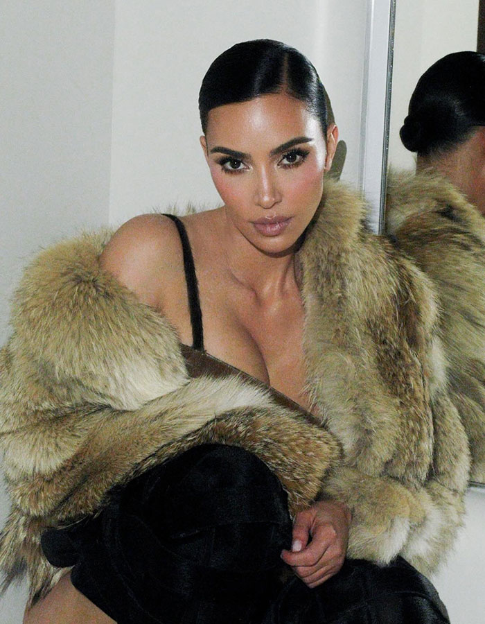 Kim Kardashian posing indoors wearing a fur coat with sleek hair, highlighting facial features and glamorous makeup. Kim Kardashian posing indoors wearing a fur coat with sleek hair, highlighting facial features and glamorous makeup.