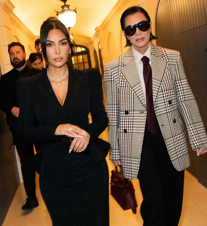Kim Kardashian and companion in stylish outfits walking in Paris during jewelry heist trial event.