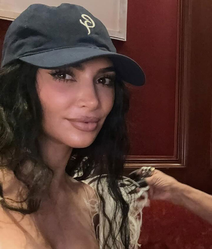 Kim Kardashian wearing a dark cap and natural makeup in Paris amid jewelry heist trial and fashion criticism.