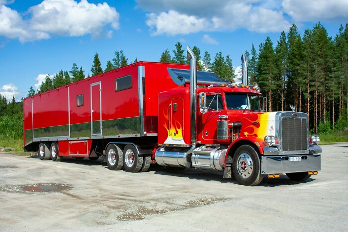Red semi-truck with flame details parked in a lot near trees, illustrating casual things that can be deadly on the road.