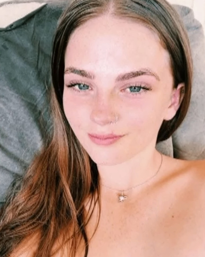 Young woman with long hair and a nose ring lying on a couch, related to Phoebe Bishop flatmate messages after teen disappearance.