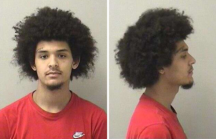 Mugshot of a young man with an afro hairstyle wearing a red Nike shirt related to the case of lesbian attacked at McDonald's restroom.