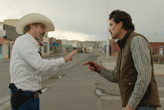 Pedro Pascal and Joaquin Phoenix in a street scene analyzed by a lip reader for an unintentional offensive hand wave.