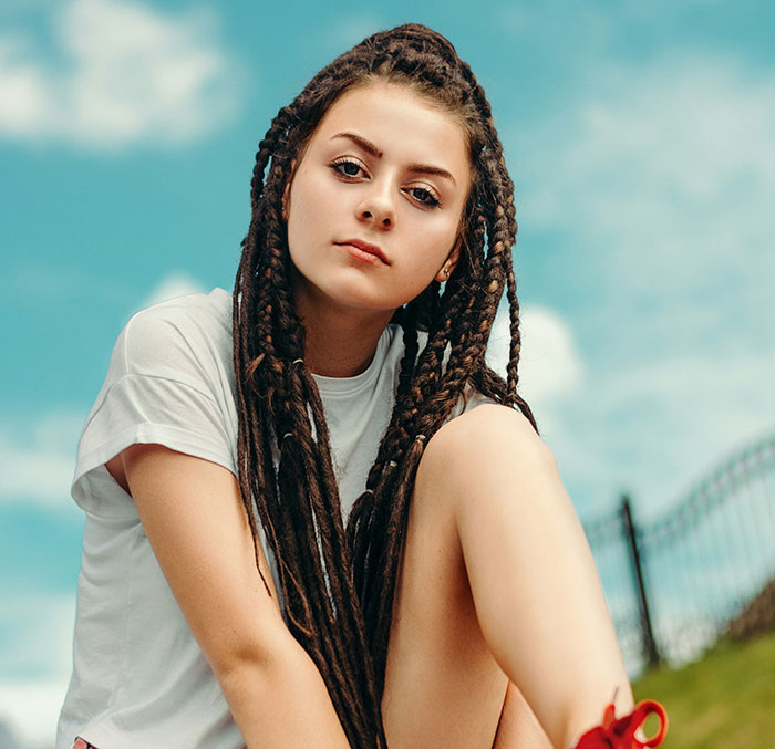 Young woman with braided hair outdoors, representing people using internet anonymity to share secrets securely.