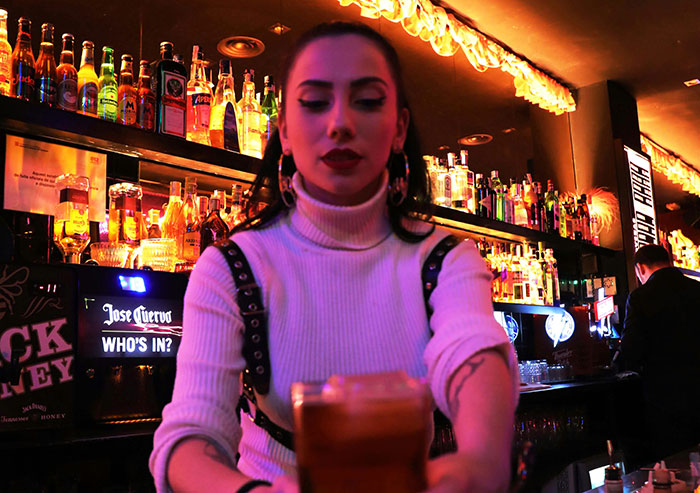 Woman in a dimly lit bar, symbolizing how people use the anonymity of the internet to share dirty little secrets.
