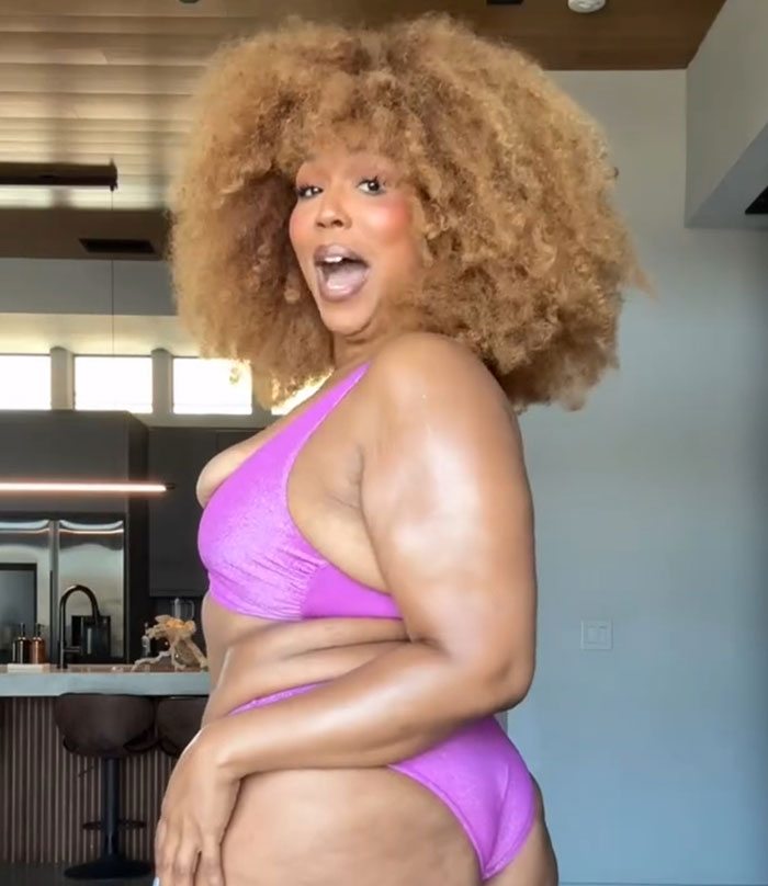 Lizzo in a purple bikini showing off her body confidently after hitting weight loss goal in a modern kitchen setting Lizzo in a purple bikini showing off her body confidently after hitting weight loss goal in a modern kitchen setting