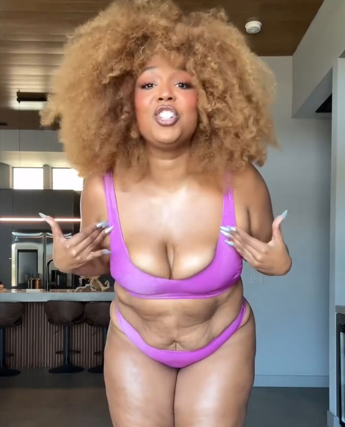 Lizzo in a purple bikini showing off her body after hitting weight loss goal in a modern kitchen setting. Lizzo in a purple bikini showing off her body after hitting weight loss goal in a modern kitchen setting.