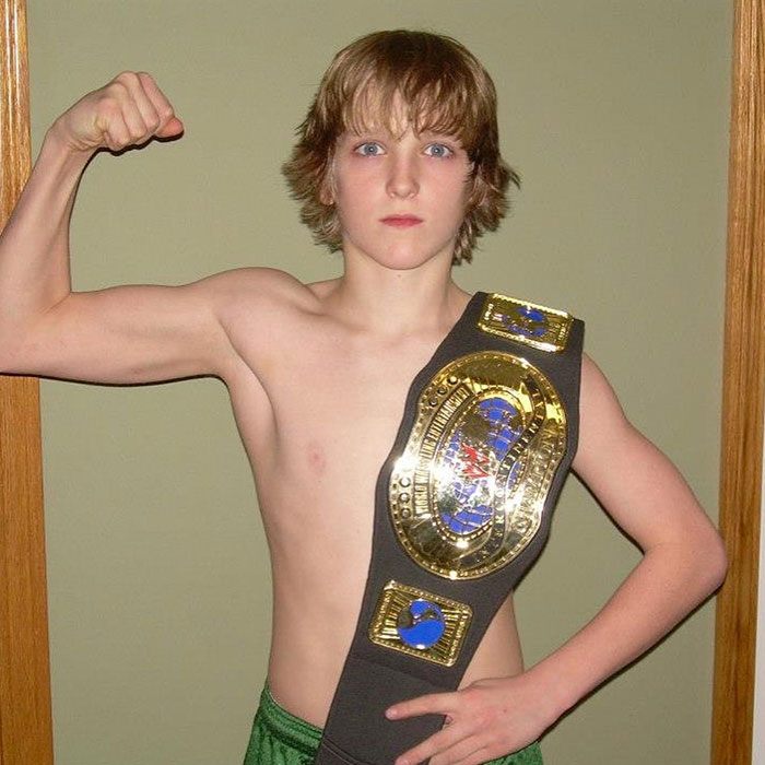Young Logan Paul flexing muscles wearing a championship belt, symbolizing Logan Paul net worth and early success in his prime years.