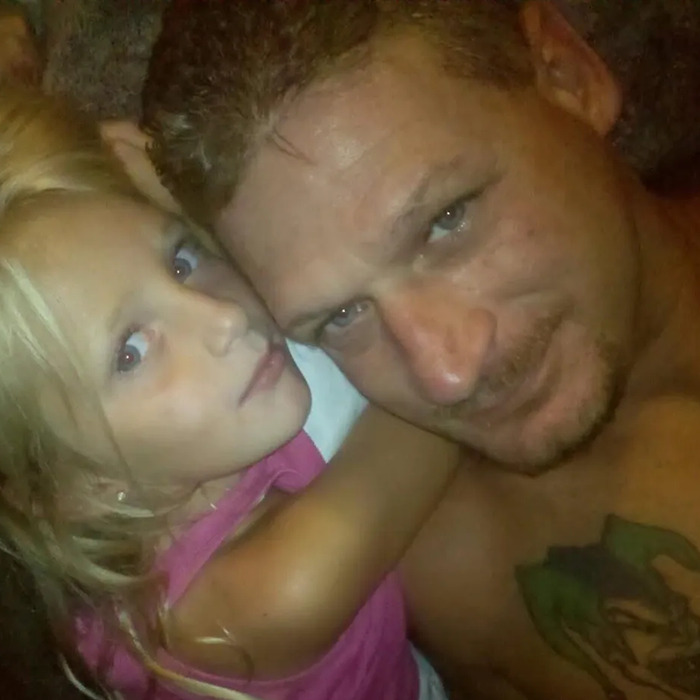 Man with tattoo and young girl in pink shirt close together, related to dad fatally beaten with metal bat news story.