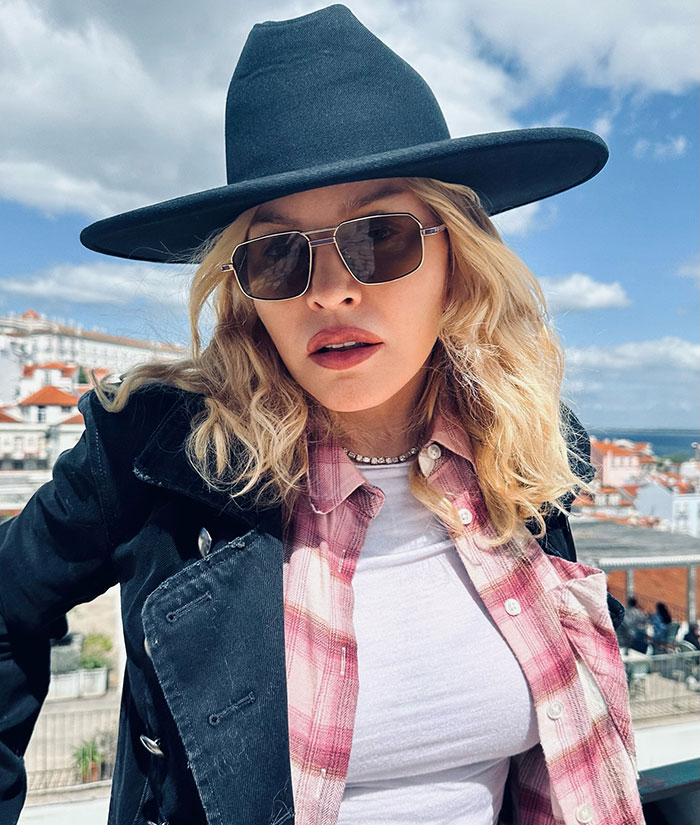 Madonna wearing sunglasses and a hat outdoors, fans notice the missing famous gap from her face.