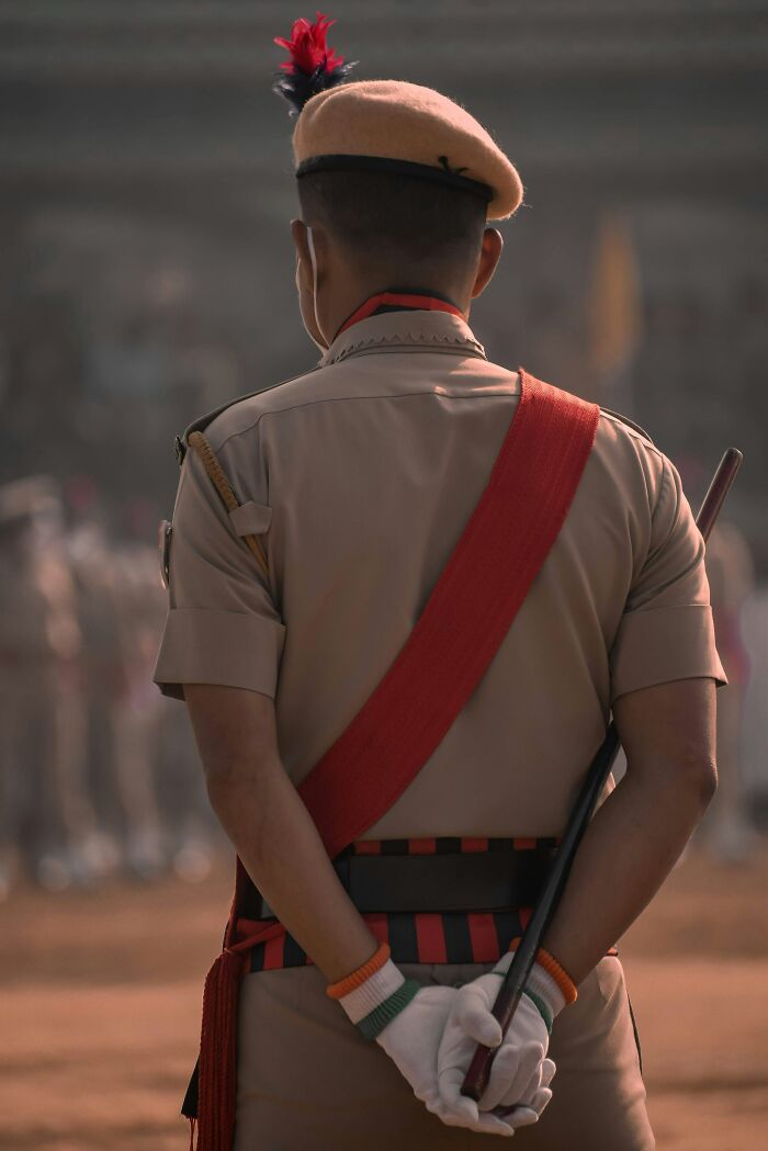 Uniformed officer in a ceremonial event holding a baton, highlighting a major event not covered by mainstream media today.