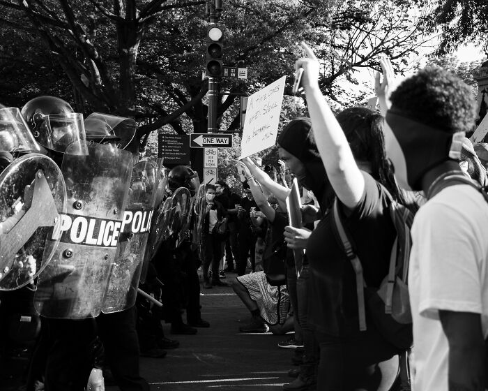 Protesters face police officers with shields during a major event not covered by mainstream media.