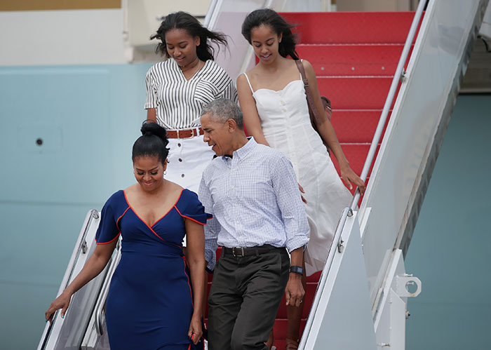 Sasha Obama shows off figure beside Malia at event, walking down stairs with parents in casual attire. Sasha Obama shows off figure beside Malia at event, walking down stairs with parents in casual attire.