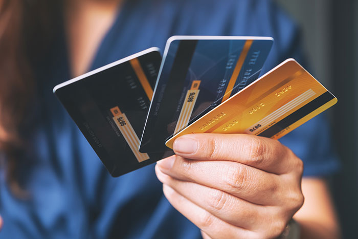 Person holding multiple credit cards, representing bride-to-be&rsquo;s secret credit card debt controversy.