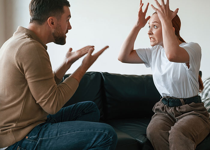 Couple arguing on a couch as guy ends relationship after girlfriend fakes pregnancy to test his love. Couple arguing on a couch as guy ends relationship after girlfriend fakes pregnancy to test his love.