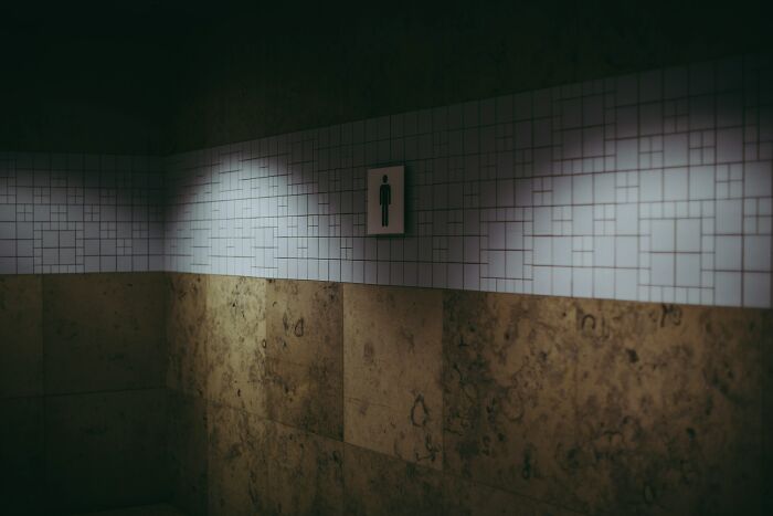 Dimly lit bar restroom corner with tiled walls, highlighting the deeper stories behind bartender jobs beyond pouring drinks.