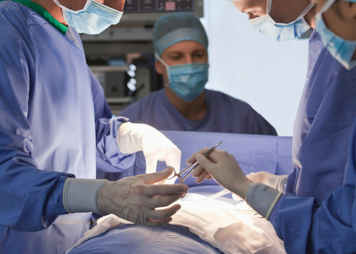 Medical workers in surgical gowns and masks performing an operation, staying calm while facing an unbelievable situation.