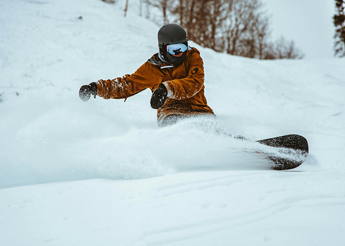 Snowboarder dressed in winter gear riding through deep snow with medical workers reacting to unbelievable scenes concept.