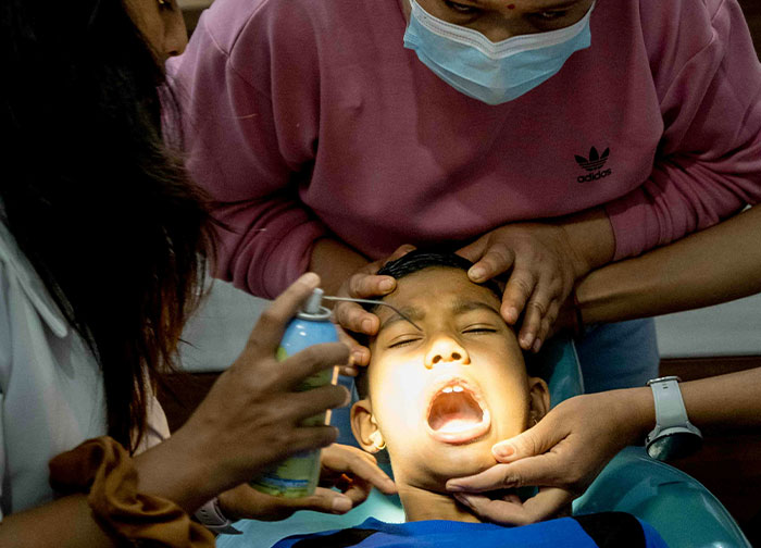 Child patient receiving eye treatment from masked healthcare workers highlighting hurtful things doctors said and did in medical care.
