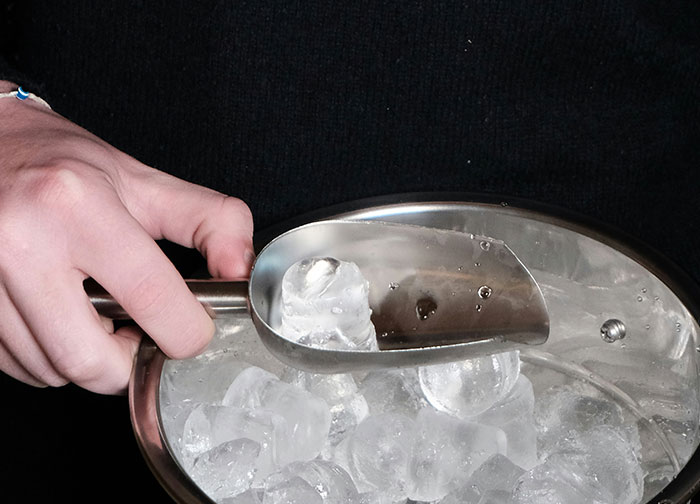 Hand holding a scoop of ice over a metal bowl, illustrating hurtful things doctors said that made patients want to change doctors.