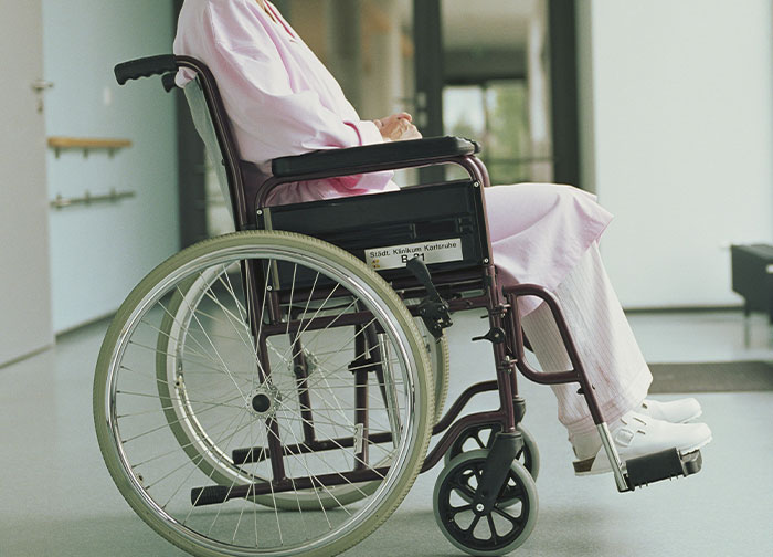 Patient sitting in wheelchair in hospital hallway representing hurtful things doctors said that made patients want to change doctors