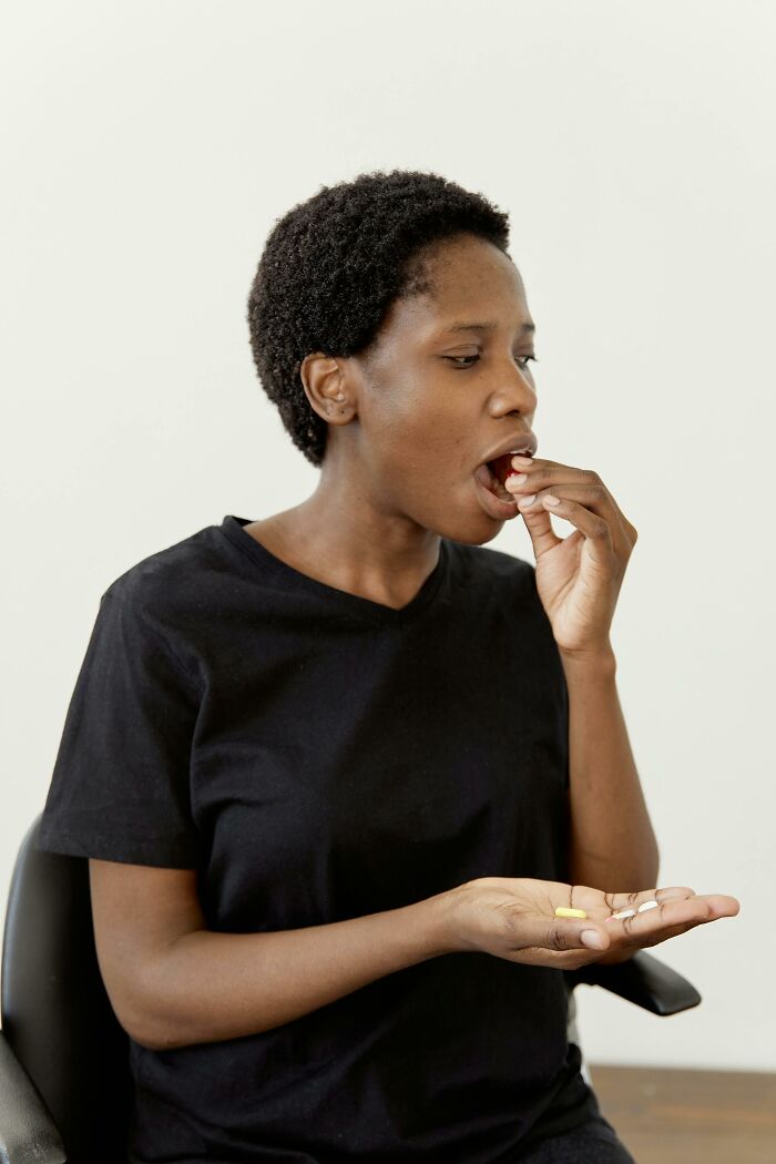 Person in black shirt taking pills illustrating mundane things that make people sick concept