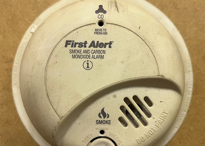 Smoke and carbon monoxide alarm mounted on a wall, showing a warning device for medical field safety awareness.