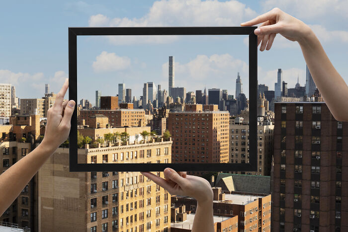 Hands holding a frame showcasing unique perspectives, symbolizing diverse and unique body features discussed by netizens.
