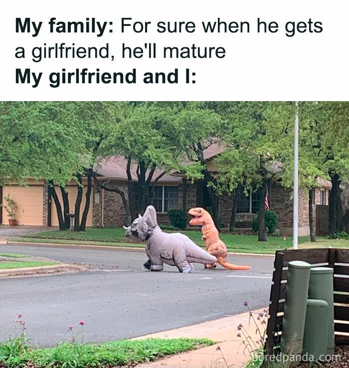 Couple dressed in dinosaur costumes crossing the street, showing unexpected wholesome memes with a playful twist.