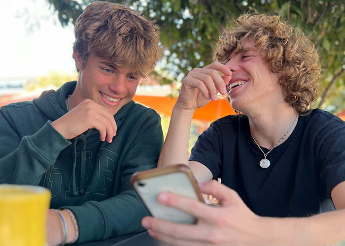 Two young men sharing a lighthearted moment outdoors, illustrating outrageous moments shared by men.