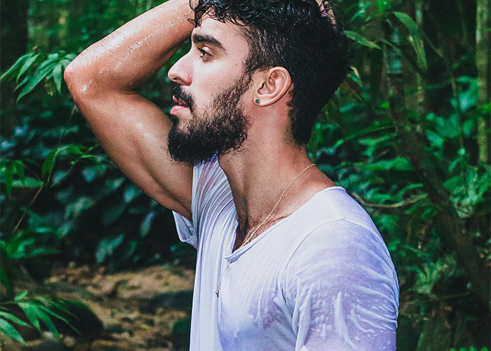 Bearded man in wet white shirt standing outdoors in nature, illustrating moments that would be outrageous if genders reversed.