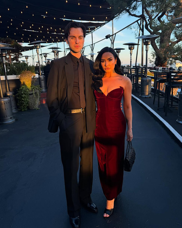 Couple dressed elegantly at sunset, with Miley Cyrus fans calling out Demi Lovato over wedding dress controversy.