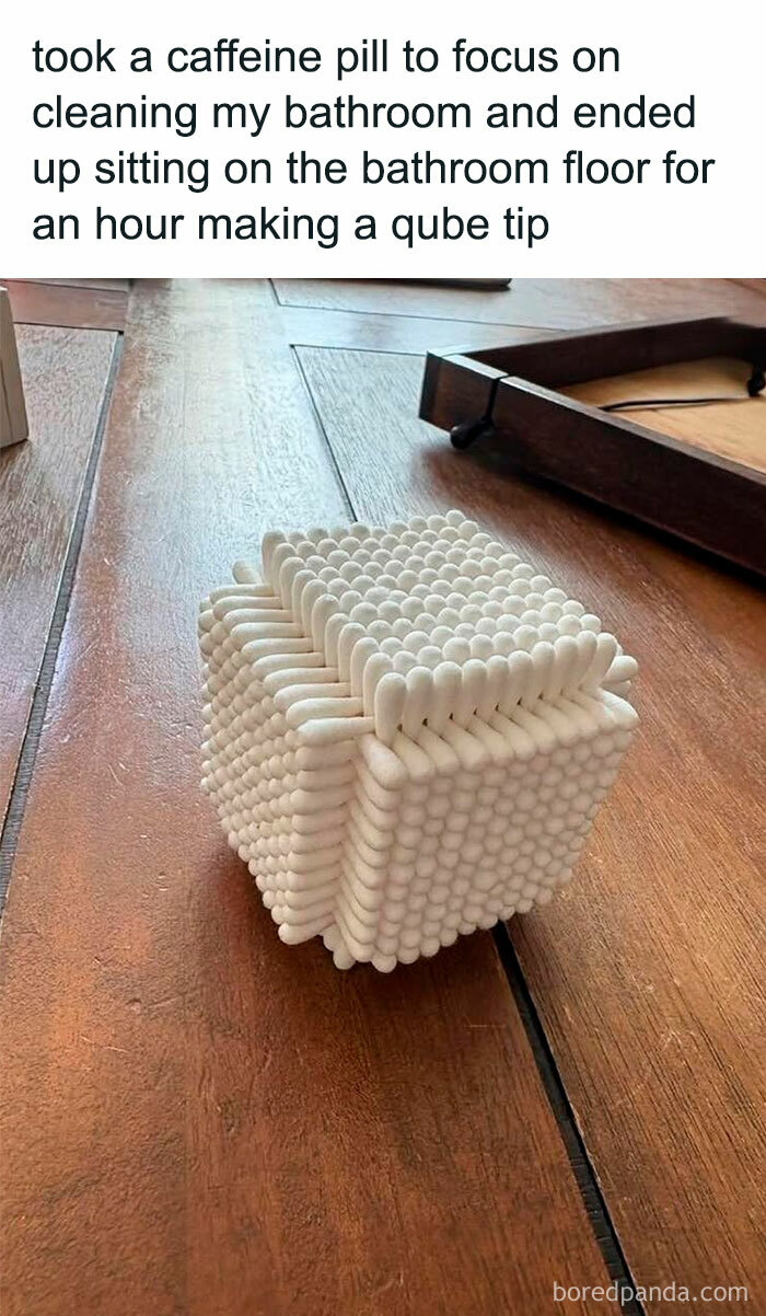 Cube made from cotton swabs on a wooden floor with a humorous caption, part of mocking posts jokes memes.