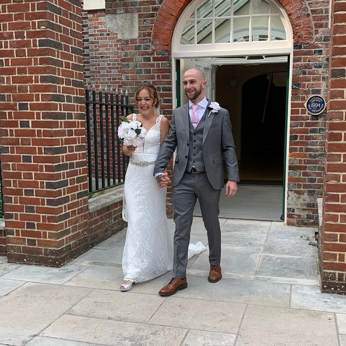 Bride and groom holding hands outside brick building, related to mom mysteriously passes away on Turkey vacation news.