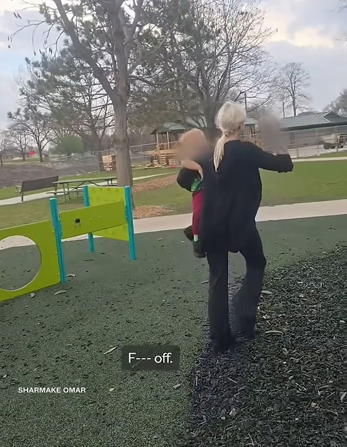 Woman carrying a child in a playground, involved in a racist incident raising controversy and funds online.