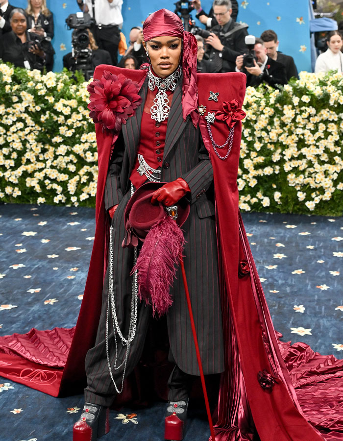 Fashion icon in a bold red ensemble on the Met Gala 2025 red carpet showcasing extravagant and breaking internet looks.