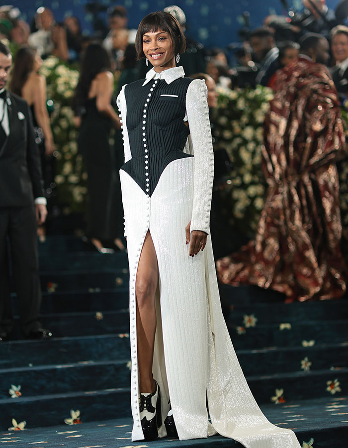 Woman in a black and white gown with high slit posing on the Met Gala 2025 red carpet.