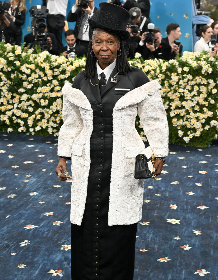 Woman in black and white textured coat with top hat and handbag posing on the Met Gala 2025 red carpet breaking the internet.