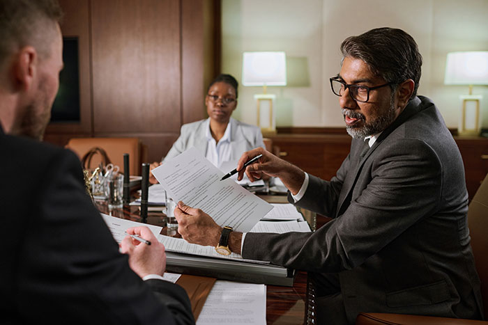 Lawyer in a suit explaining legal documents to a man during a consultation about raising a newborn alone and ex reappearing.