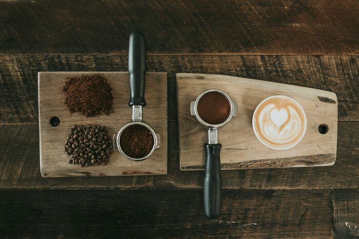 Coffee beans, ground coffee, and espresso with latte art on wooden boards showing food prices comparison.