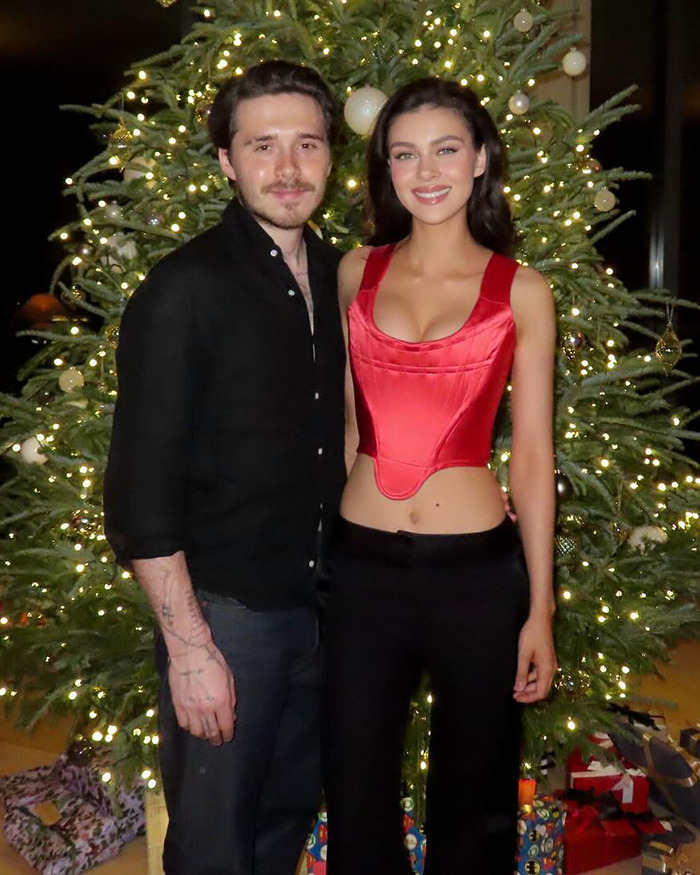 Nicola Peltz and Brooklyn Beckham posing by a decorated Christmas tree amid rumored family feud and narcissistic claims.