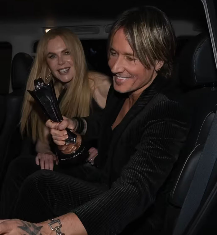 Nicole Kidman and a man smiling inside a car, Nicole Kidman wig blunder caught at Cannes red carpet event.