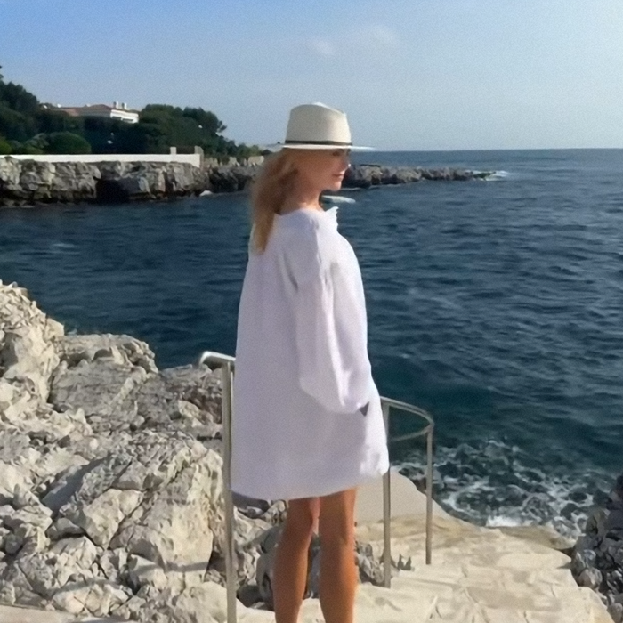 Nicole Kidman outdoors near ocean wearing white outfit and hat showing her natural hair after wig fail at Cannes.