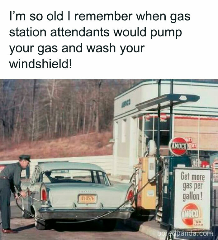Vintage gas station attendant pumping gas and washing windshield at an old Amoco station in nostalgic photo.