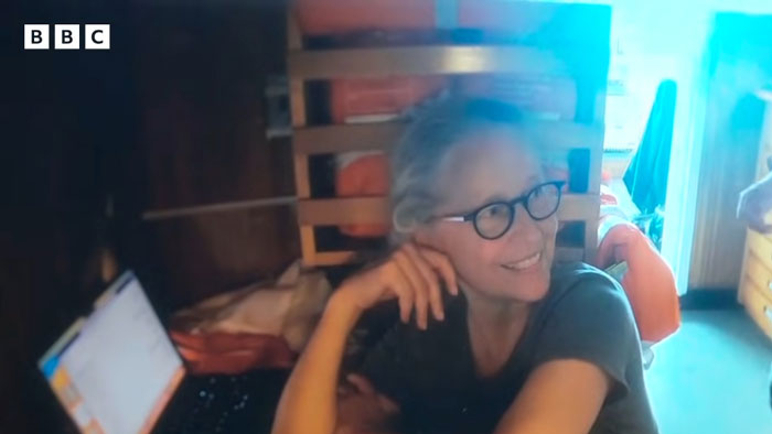 OceanGate CEO’s wife wearing glasses, smiling, sitting indoors near a laptop with a wooden chair in the background. OceanGate CEO’s wife wearing glasses, smiling, sitting indoors near a laptop with a wooden chair in the background.