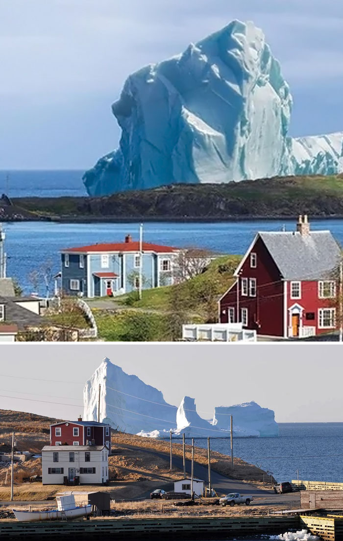 Massive iceberg towering over small coastal houses, showcasing an impressive example of megalophobia and extreme size contrast.